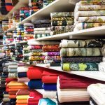 Rolls of fabric and textiles in a factory shop or  store or bazar. Multi different colors and patterns on the market. Industrial fabrics.