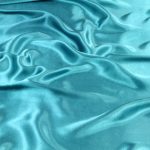 Turquoise wavy silk fabric background